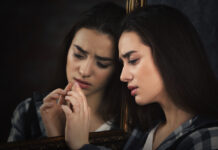 Self-Labeling with Psychiatric Terminology May be Harmful for Youth young woman and her reflection in mirror