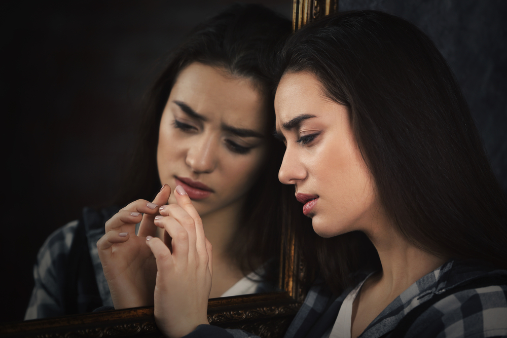 young woman and her reflection in mirror