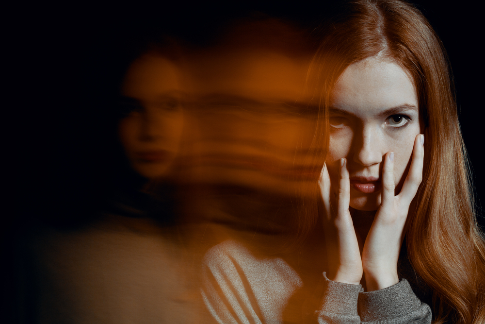 A woman holds her face; multiple reflections