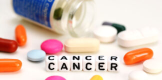 Cancer Risk Higher for Those on Clozapine Letter blocks spelling "CANCER" and spilled pills in various colors on a white background