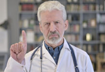 Psychiatry’s Denial of the Horrors of Tardive Dyskinesia Photo of older white doctor with beard shaking his finger "no"