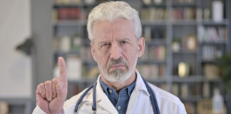 Psychiatry’s Denial of the Horrors of Tardive Dyskinesia Photo of older white doctor with beard shaking his finger "no"