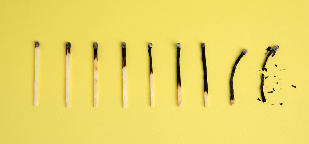 Different stages of burnt matches on yellow background, flat lay