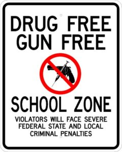 Sign reading "DRUG FREE GUN FREE SCHOOL ZONE"