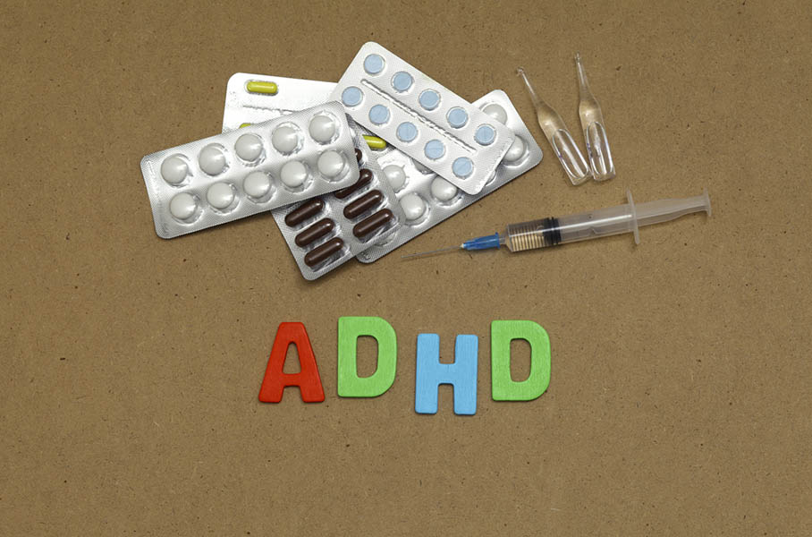 Pills against a brown background. The word "ADHD" is beneath.