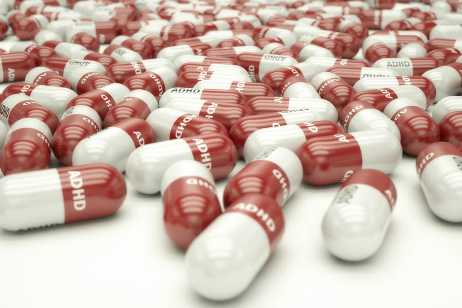 3D illustration of a bunch of red and white pills labeled "ADHD"