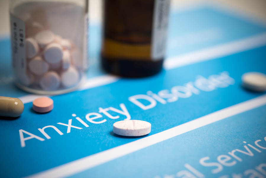 Closeup photo of pills on a sheet that reads "Anxiety Disorder"