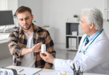 Antipsychotics Lead to Worse Outcomes in First-Episode Psychosis Young man refusing to take prescribed pills in clinic