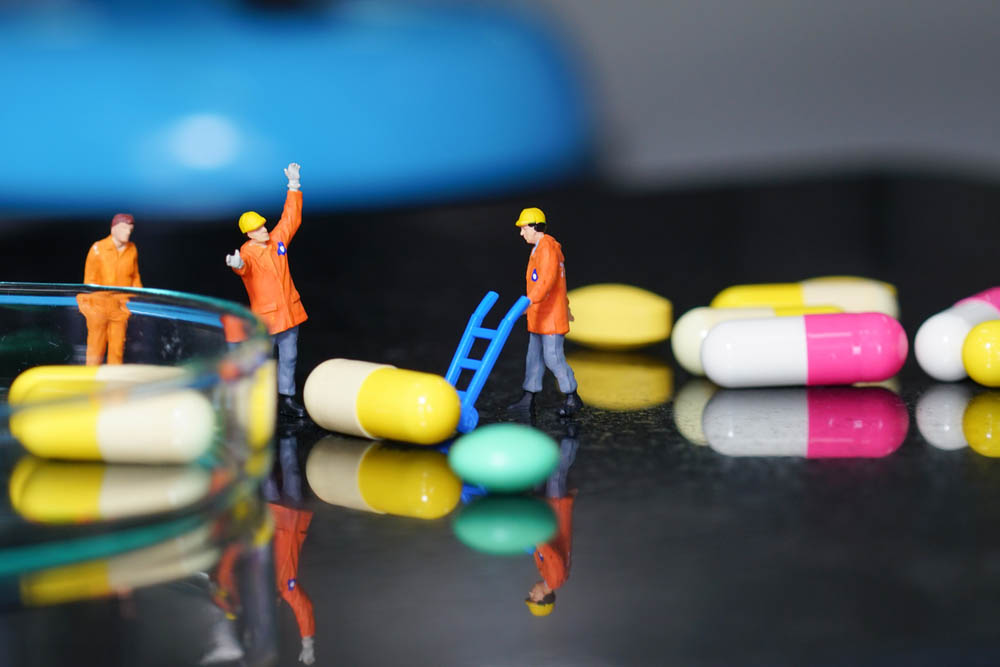 Miniature people - The worker at work with medicine pills