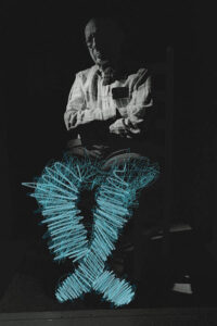 Dr. Gordon Warme, an older man, on a black background, with blue painted scribbles lighting up his legs