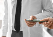 Millions of Dollars of Pharma Money Went to the DSM-5-TR Authors Closeup on money being handed to a doctor