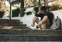 Universities’ Mental Health Policies: Punitive, Problematic, and In Need of Reform Mental health, depression and anxiety with student on stairs with backpack for failure, fear and mistake. Sad, stress or bullying with black man on steps of college campus for frustrated or problem.