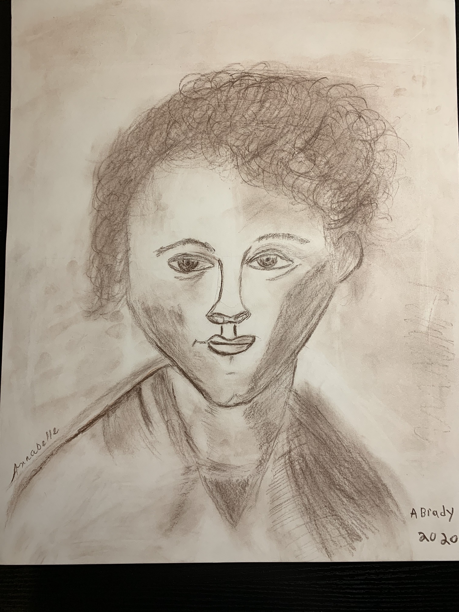 A drawing in charcoal or pastel of a person with short curly hair