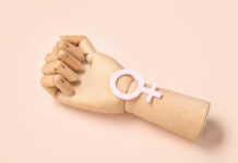 Gender and Psychiatry: Pathologized Emotions Wooden hand with female gender symbol on pink background