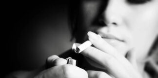 Smoke ‘Em if You Got ‘Em: Rethinking Smoking as a Trauma Response B&W photo of a young woman smoking. Close-up on the cigarette being lit by a lighter; her face is out of focus