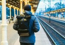 Exile: My Cure for Psychosis Train Station in Sopot, Poland, Europe. Attractive man waiting at the train station. Thinking about trip, with backpack. Travel photography. tourist with backpack stand on railway station platform.