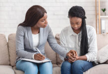 Beyond Techniques: The Common Factors That Drive Healing Professional Support. Psychologist comforting depressed female patient during therapy session in office
