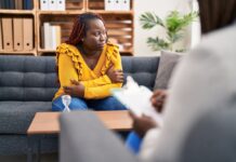 African american women psychologist and patient having mental therapy sitting on sofa at psychology clinic