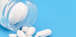 Animal Study: SSRI Neurotoxic in Pregnancy Close up of Pills spilling out of pill bottle on blue background. with copy space. Medicine concept .