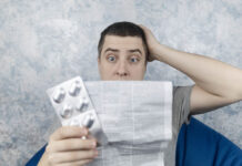 False Information in UK Package Inserts for Antidepressants About a Chemical Imbalance Man on a white background reads the instructions for medicines. Male looks at the list and composition of the drug. The concept of home self-medication and the study of the properties of drugs