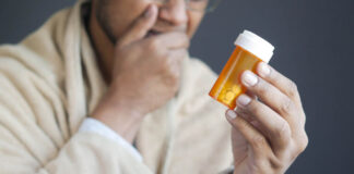 Half of Those Who Take Antidepressants Are Labeled “Treatment Resistant” A person, out of focus, holding a pill bottle in focus