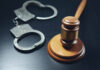 A gavel and open handcuffs