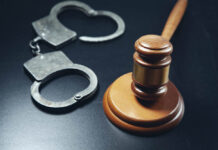 A gavel and open handcuffs