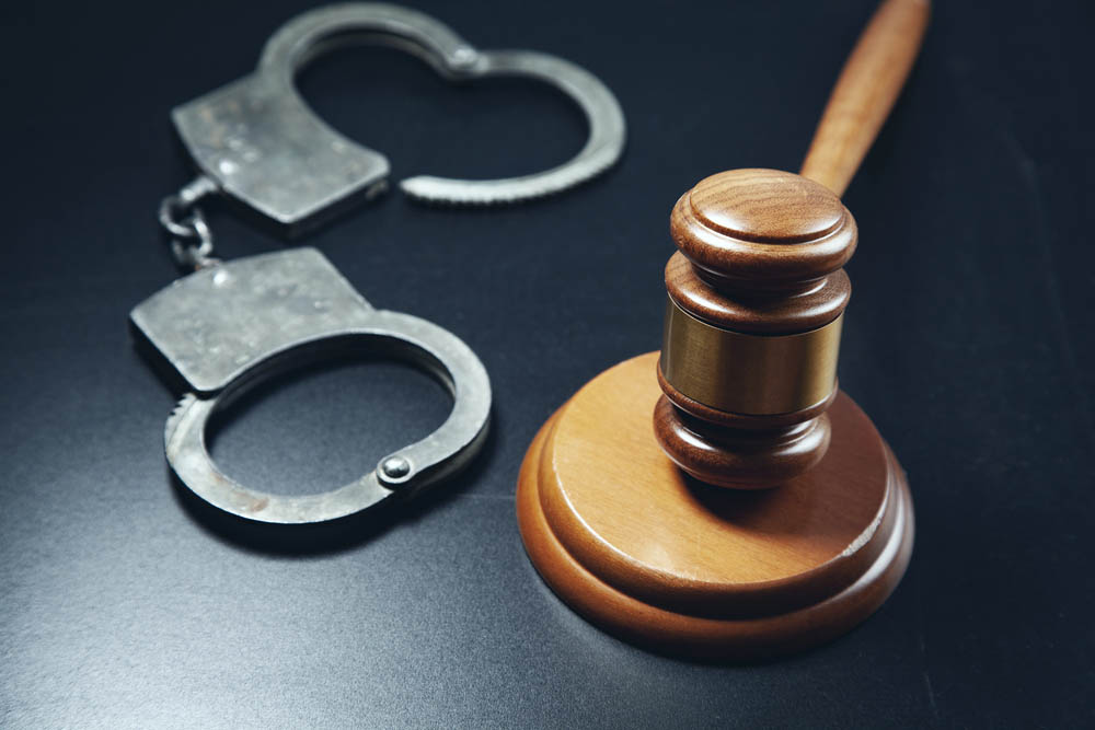 A gavel and open handcuffs