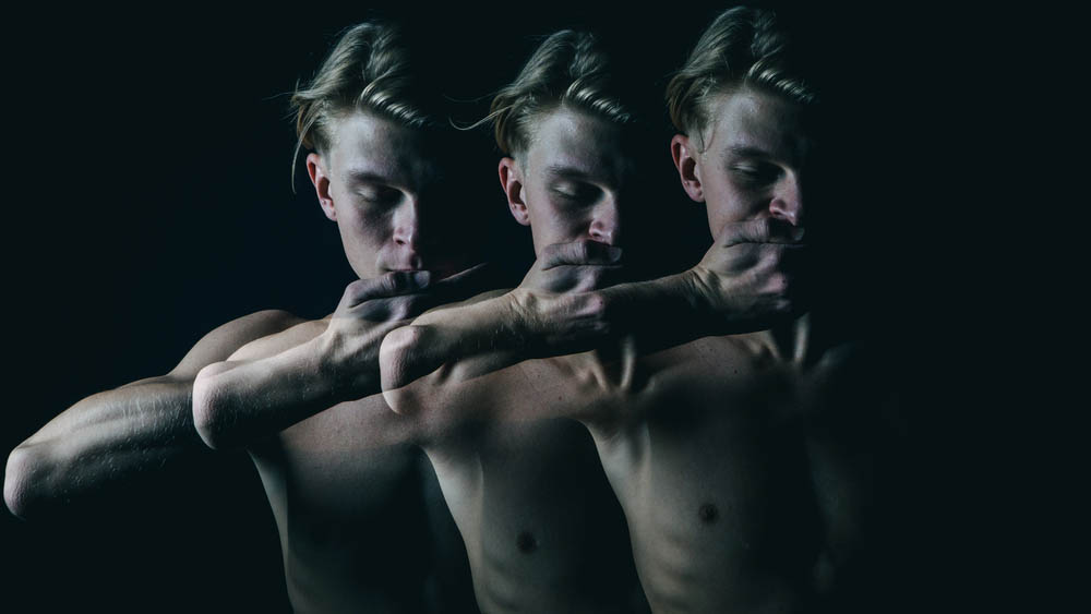 Triple exposure of young man holding hand over mouth