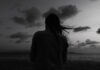 Alone woman at the beach one twilight time looking out to sea