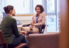 Female College Student Meeting With Campus Counselor Discussing Mental Health Issues