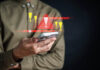 Holding a cell phone, warning symbols flashing in the air