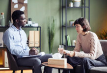 Black male therapist listening to White female client