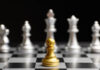 Chess photo. A gold pawn faces against a line of silver pieces