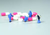 Miniature scientist at work with Medicine pills