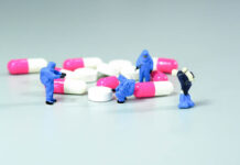 Miniature scientist at work with Medicine pills