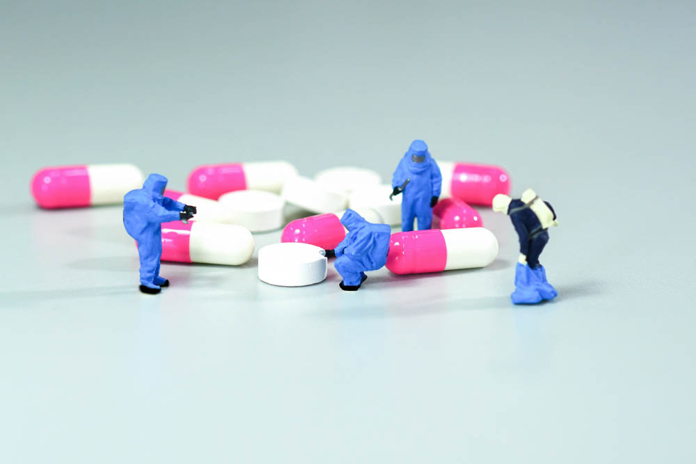 Miniature scientist at work with Medicine pills
