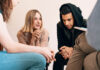 Group of teenagers sitting together and smiling during a support meeting