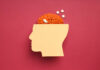 Paper head with brain and pills on red background