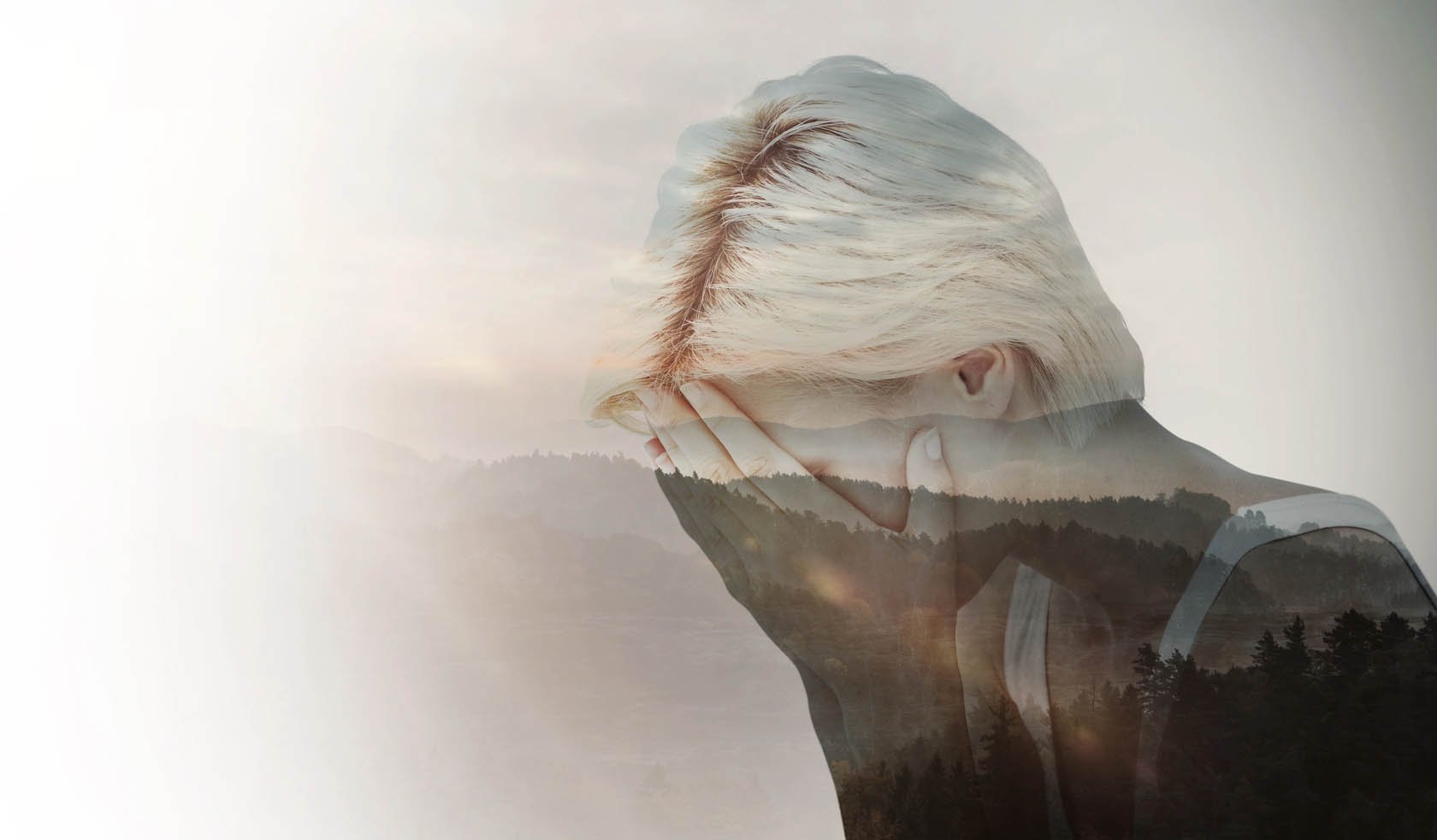 Double exposure; sad woman with forest in background