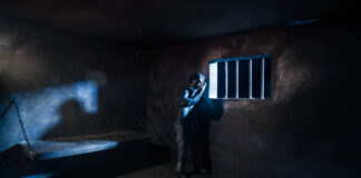 Fifty Years of Grief Miniature photography. Lonely man bathed in moonlight in a prison cell