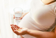 Supplements vitamins pill. Happy young pregnant woman holding supplement vitamin pill. Therapy, healthcare, motherhood concept