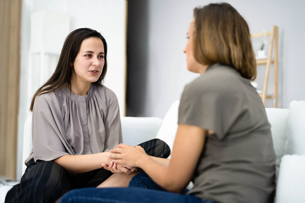 Female therapist hand on female client's hand
