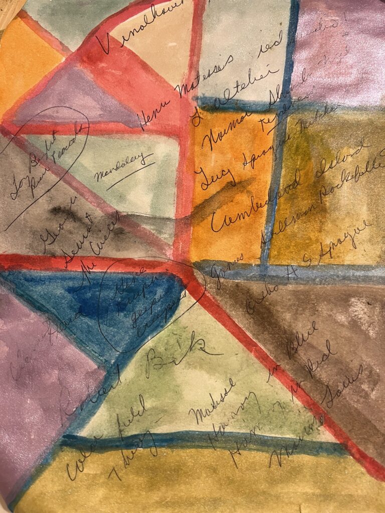 Triangles and rectangles of paint colors separated by red and blue lines, with cursive words scribbled over them in ink