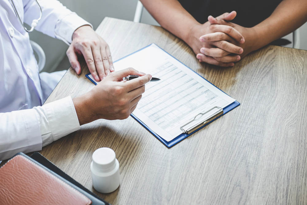 Doctor having conversation with patient while discussing explaining symptoms or counsel diagnosis health and consult treatment of disease, healthcare and assistance concept.