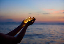 In Defense of Instability in Mental Health Recovery Holding tiny lights up in cupped hands at sunset