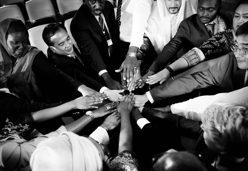 Diverse people placing hands together in solidarity