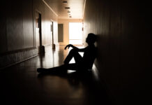 What Do Psych Survivors Want Instead of Psychiatric Coercion? Silhouette, distressed male sitting in hallway, hospital, dark