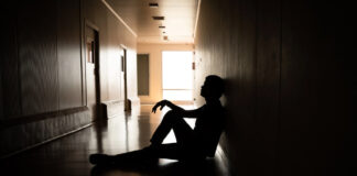 What Do Psych Survivors Want Instead of Psychiatric Coercion? Silhouette, distressed male sitting in hallway, hospital, dark