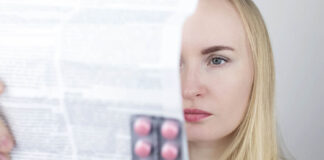 Depression Drug Approved by FDA Had 11 Failed Trials and an Advisory Committee Vote Against Approval A blonde white woman reads the product label for drugs in blister pack in her hand